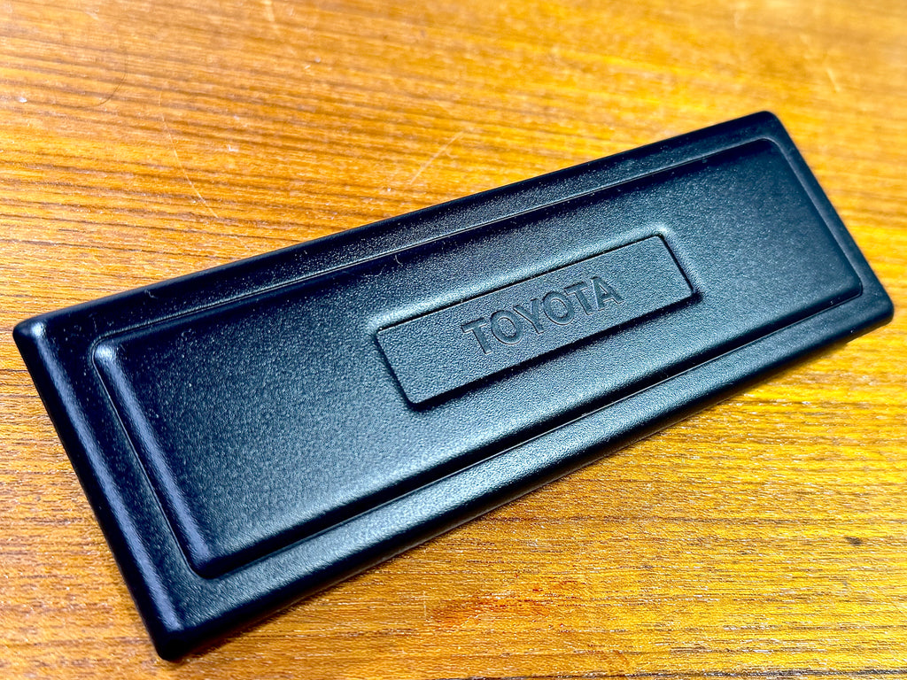 NOS OEM TOYOTA FULL SIZE Single DIN. RADIO TUNER , CONSOLE BOX OPENING DELETE Plate  Bold LOGO Combined with a Picture Frame Layout   COVER PLATE