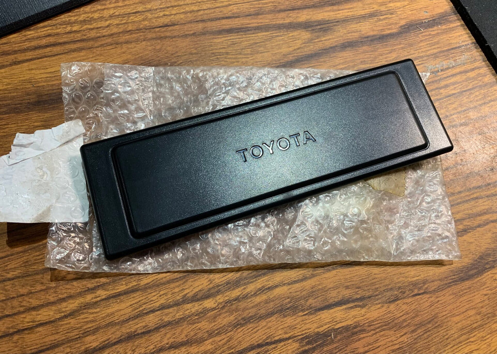 NOS OEM TOYOTA FULL SIZE Single DIN. RADIO TUNER , CONSOLE BOX OPENING DELETE Super Kool TOYOTA Bold LOGO Combined with a Picture Frame Layout CAT'S MEOW   COVER PLATE